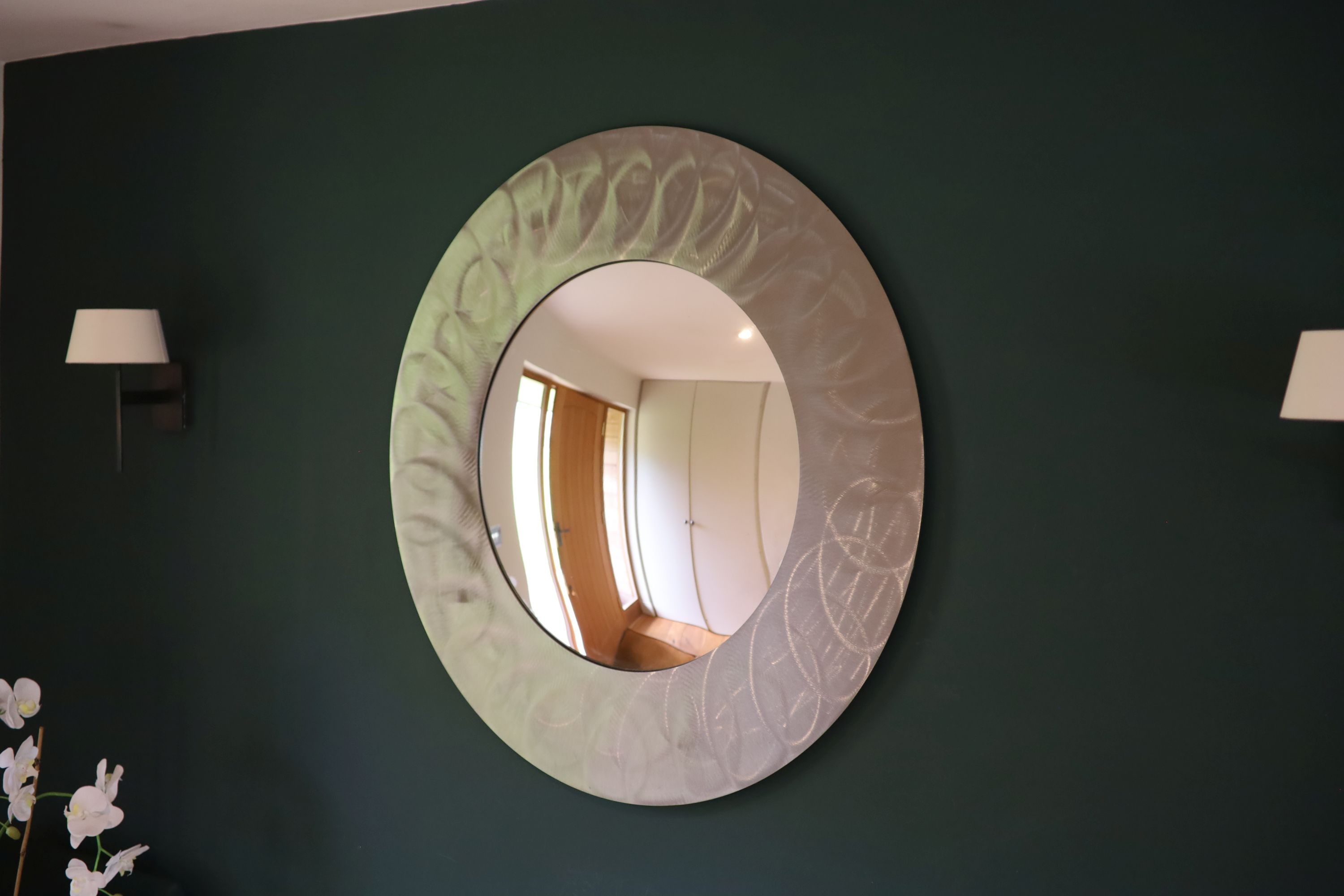 A brushed steel circular wall mirror, 96cm